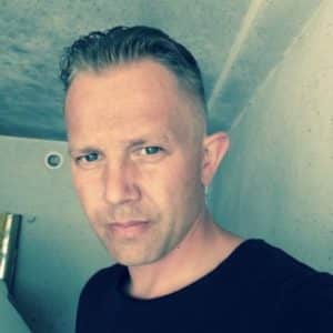 Mann mit zurückgegelten Haaren schaut ernst