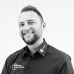 Lächelnder Mann in schwarzem Hemd, Schwarz-Weiß-Foto