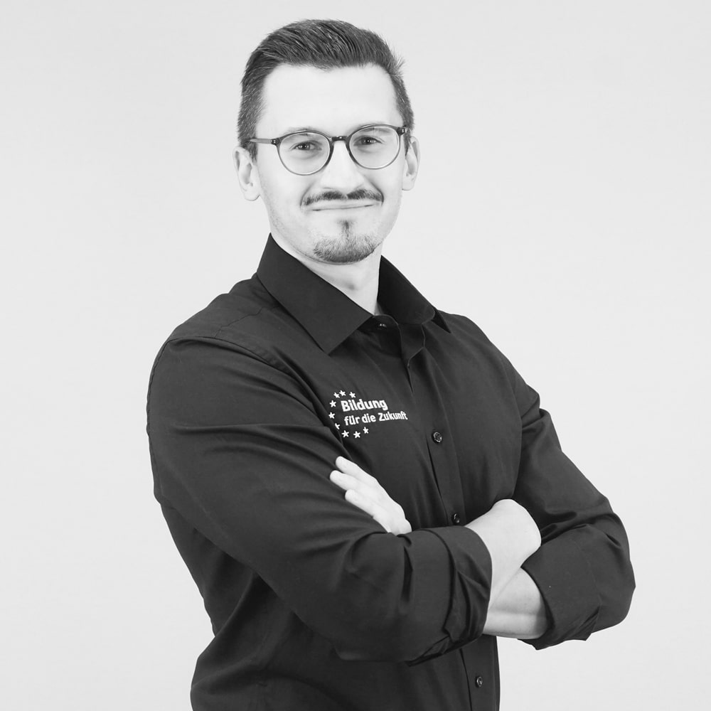 Mann in schwarzem Hemd mit verschränkten Armen